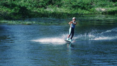 漂亮的女孩尾波滑水夏天河女人练习水滑雪